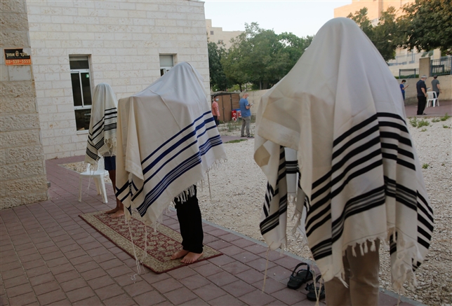 Jewish religious pray outside to insure social distancing spread of the Covid-19 in Modiin