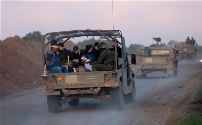 Israeli soldiers transfer detained Palestinians out of the Gaza Strip on November 20, 2023